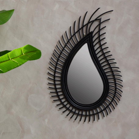 Decorative wall mirror with black teardrop frame on a light beige background