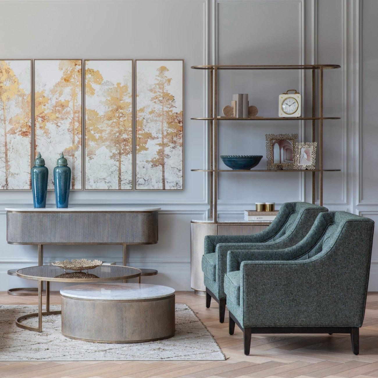Modern living room with green armchairs, round coffee table, and decorative wall art.
