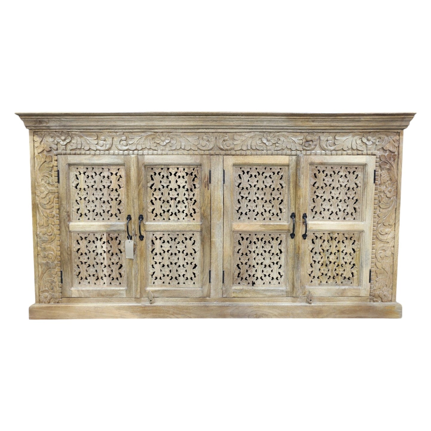 A large, hand-carved solid wood sideboard measuring 190cm wide by 101cm high, featuring four intricately detailed doors with metal handles. The natural rustic finish highlights the ornate floral and geometric carvings, adding a touch of artisanal craftsmanship. Behind the doors are two spacious cupboards with internal shelves, offering ample storage. The wide counter-top provides additional surface space, making this piece both functional and decorative for various interior settings.