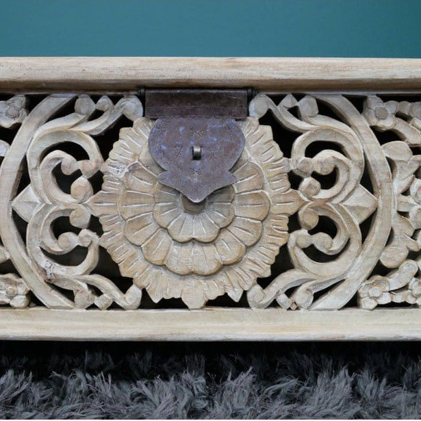 A handcrafted storage bench made from solid mango wood, measuring 135cm wide, 40cm deep, and 46cm high. The bench features a whitewashed finish and intricately carved floral and geometric patterns on its front panel. It includes a lift-up lid revealing a spacious internal compartment, offering both seating and storage solutions. The rustic design and boho craftsmanship make it suitable for various interior styles, including bohemian, farmhouse, and eclectic decors.