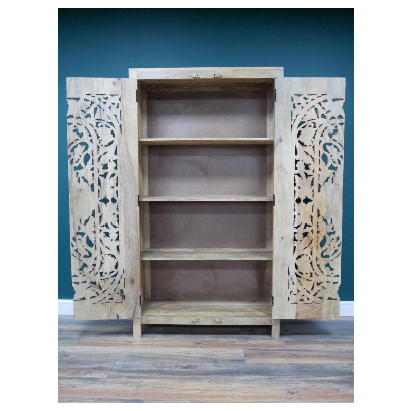 A tall, hand-carved solid mango wood cabinet measuring 180cm in height, 100cm in width, and 40cm in depth. The cabinet features two full-length doors adorned with intricate floral and geometric carvings, reflecting Eastern design influences. Finished in a natural wood tone, this piece offers ample internal storage with shelved compartments, making it both functional and decorative. Suitable for various interior styles, including bohemian, rustic, and eclectic homes.