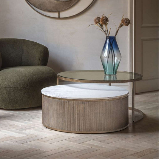 Two round coffee tables: one with a white marble top and ribbed base, the other featuring a glass top and sleek gold metal frame, for a contemporary look.