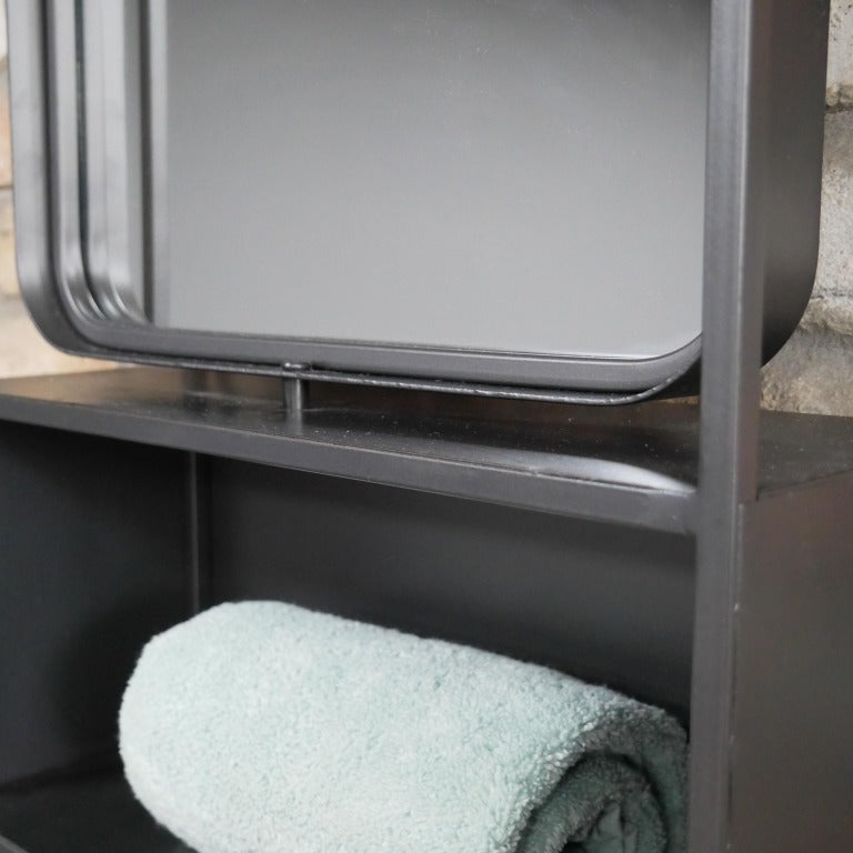 Keep your home stylishly organised with our Industrial Black Wall Mirrored Unit! This large rectangular shelf boasts a sleek black metal finish that screams industrial chic. Two spacious shelves are just begging to showcase your favourite things, and the built-in mirror at the top also adds that perfect rustic flair. With easy-to-use hooks for mounting, this playful piece will jazz up any bathroom, hallway, or kitchen!