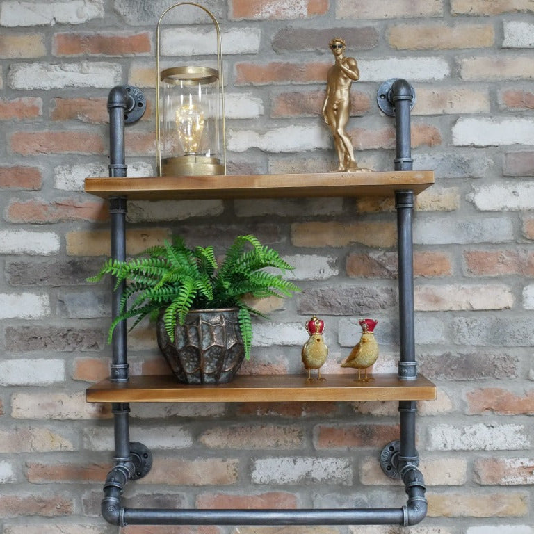 Our Industrial Pipe Wall Shelf boldly combines rugged steel grey metal pipes with warm solid wood shelves, creating a striking urban statement. The dark pipe frame brings an industrial vibe, while the rich wood shelves soften the look, balancing raw and refined. Perfect for showcasing your unique decor, this wall-hung unit features four sturdy fixing plates for secure hanging.