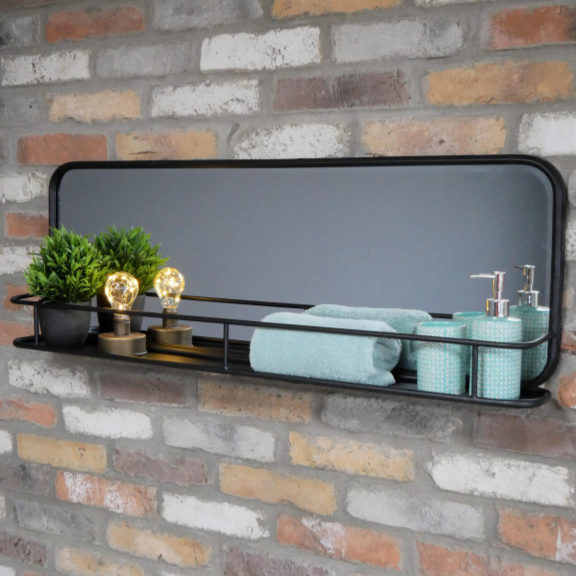 Rectangular mirror with a black frame on a brick wall