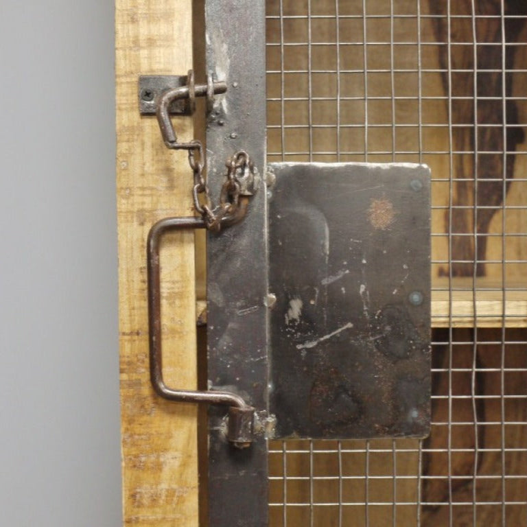 This Industrial Wood and Metal Cabinet combines rustic mango wood with durable metal for a stylish, practical storage solution. Featuring four compartments visible through a metal mesh door secured by a unique chain lock, it offers both elegance and security. Its industrial-worn metal fittings and sturdy wooden legs ensure stability, making it ideal for living rooms, hallways, or bedrooms.