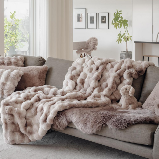 Cozy living room with a sectional sofa covered in a fluffy beige throw blanket.