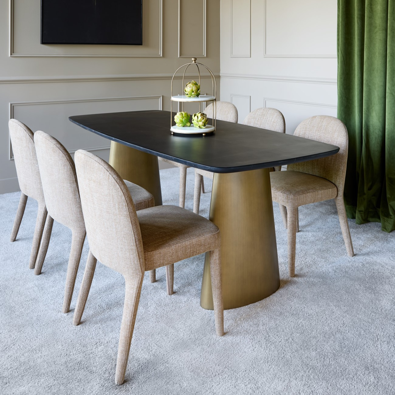 Dining room with a modern black and gold table and chairs.