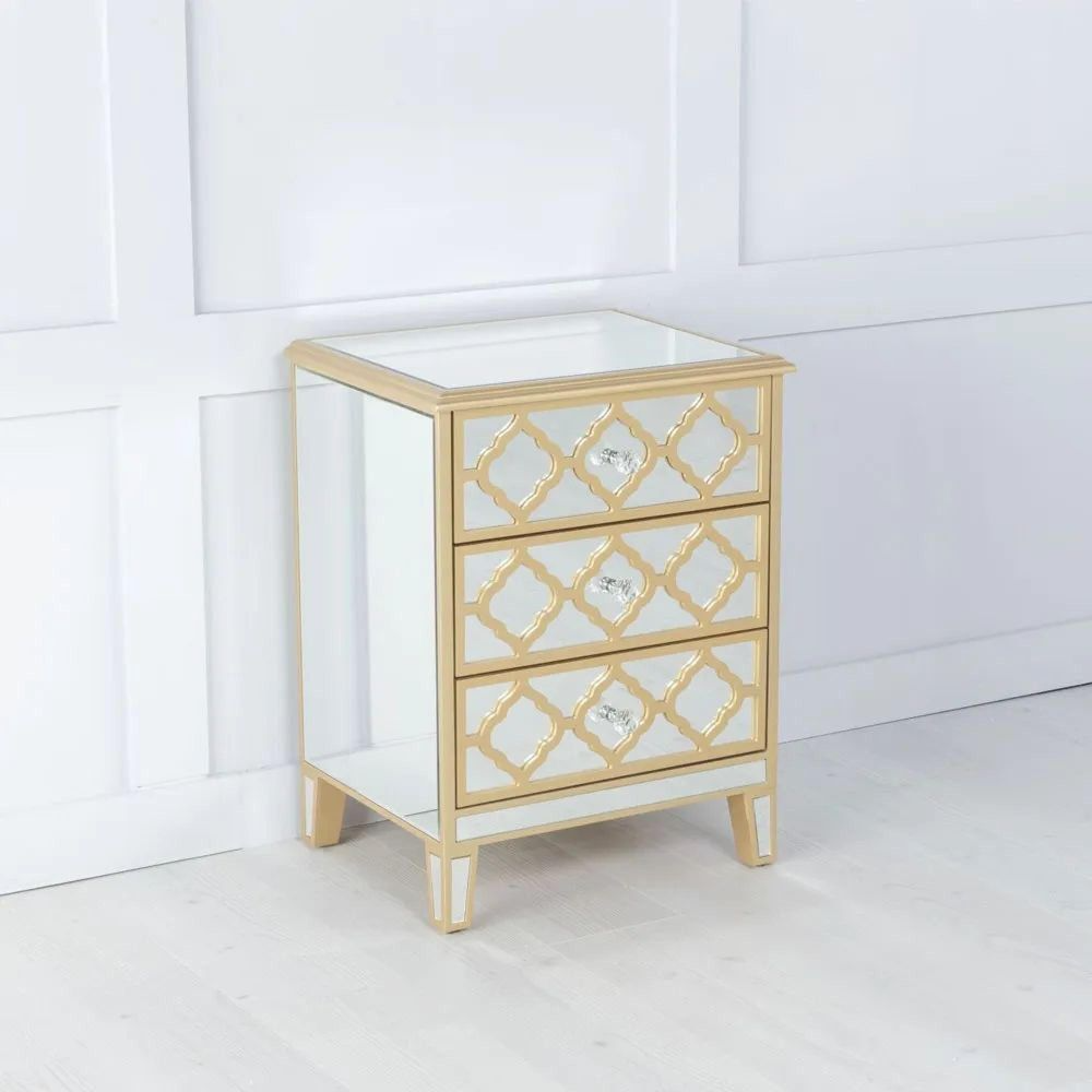 Gold-framed mirror chest of drawers against a white wall