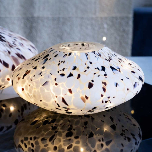 Decorative lamp with a textured surface on a reflective surface.