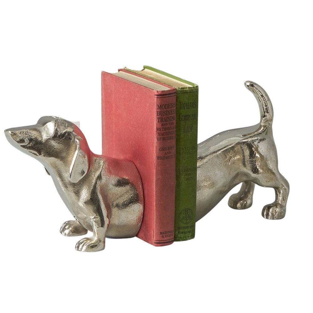 A pair of bookends, in silver metal, in the shape of a sausage dachshund dog. The books slot into the middle. A perfect gift for dog lovers and bookworms!