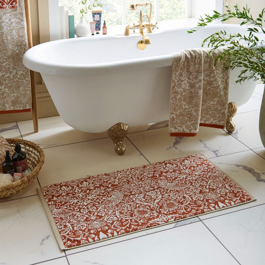 Bathroom with a freestanding bathtub and patterned bath mat