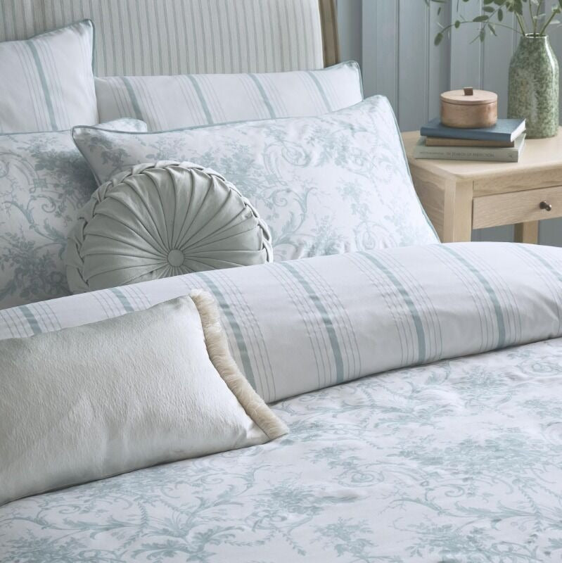Bed with patterned bedding and pillows in a bedroom setting.