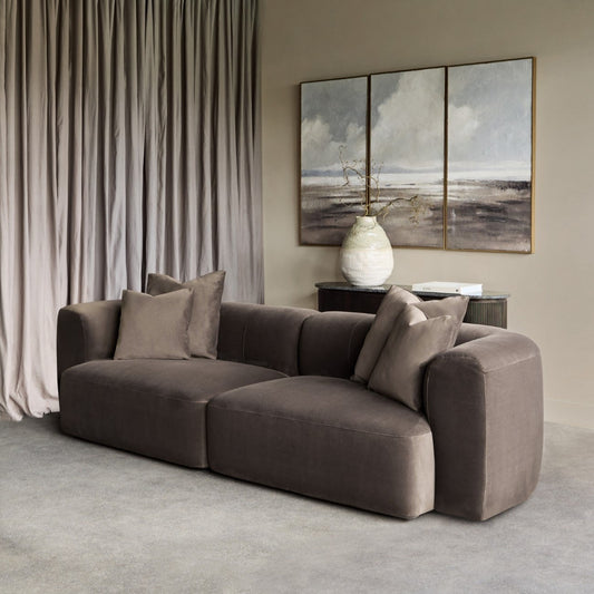 Modern living room with a brown sofa, neutral decor, and abstract wall art.