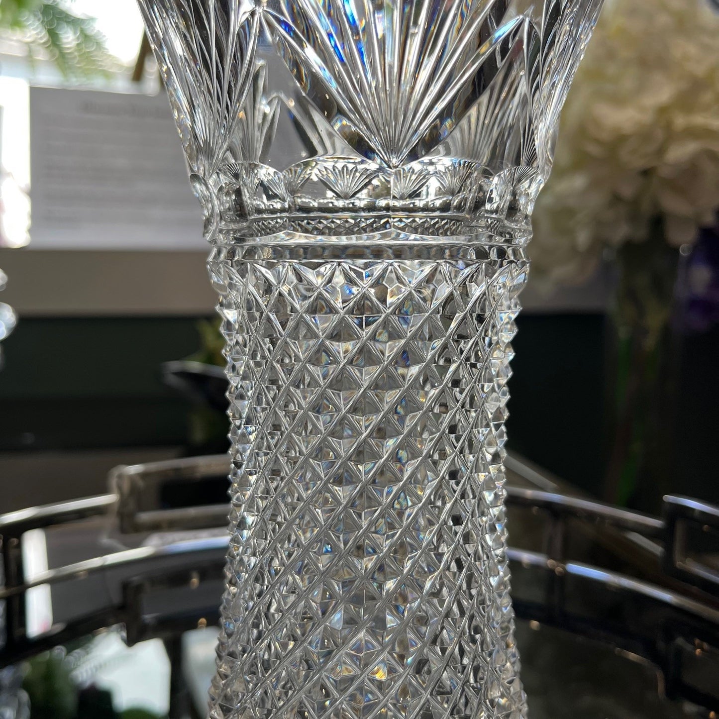 Clear crystal vase with intricate patterns on a blurred background