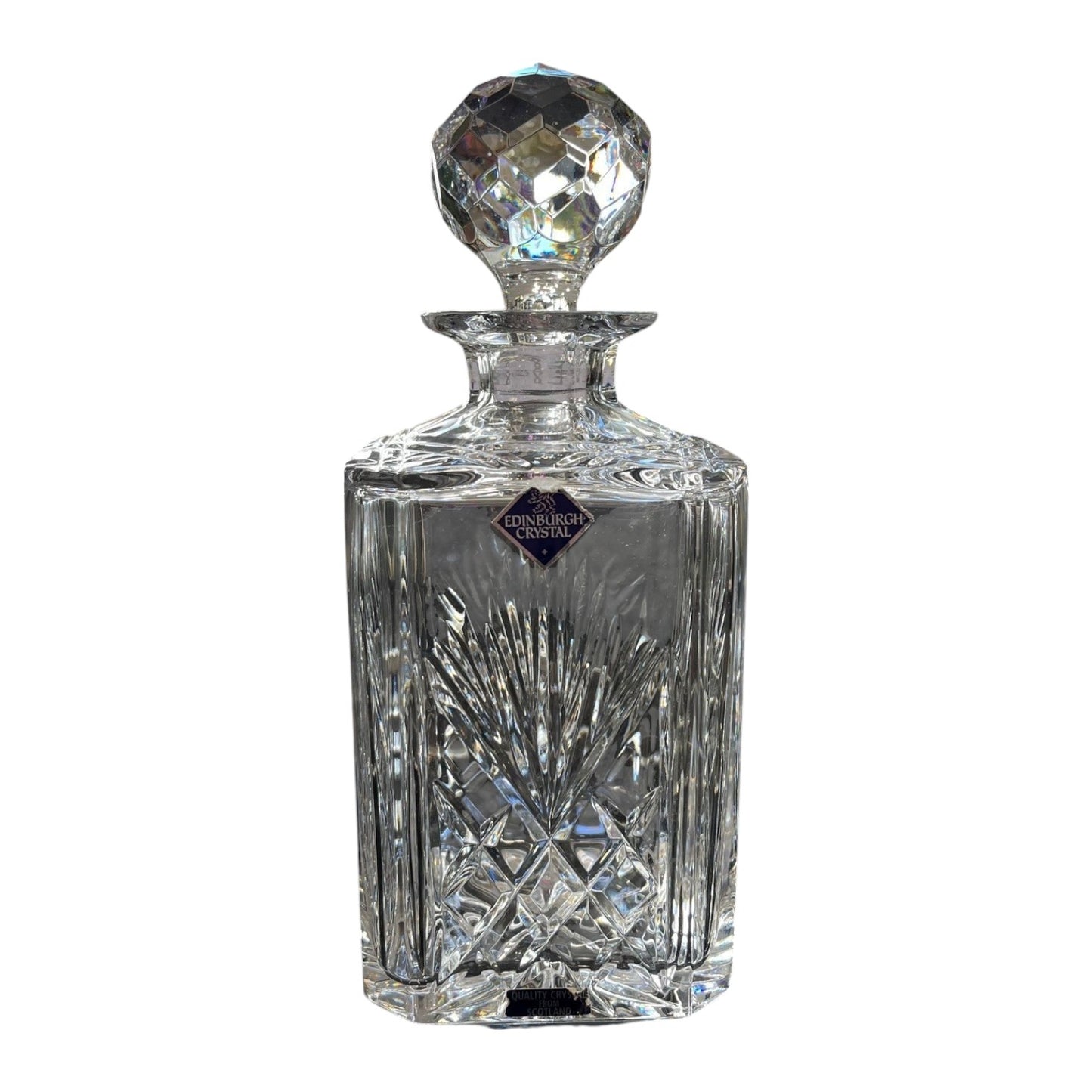 Crystal decanter with intricate design on a white background