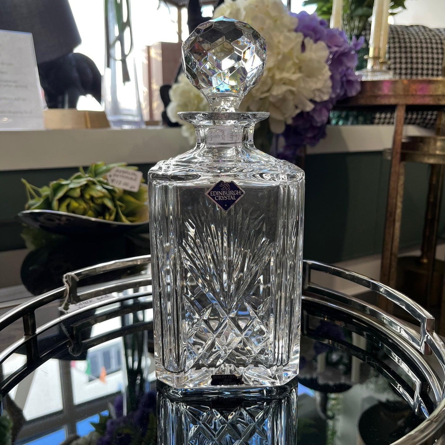 Crystal decanter with 'Edinburgh Crystal' logo on a reflective surface