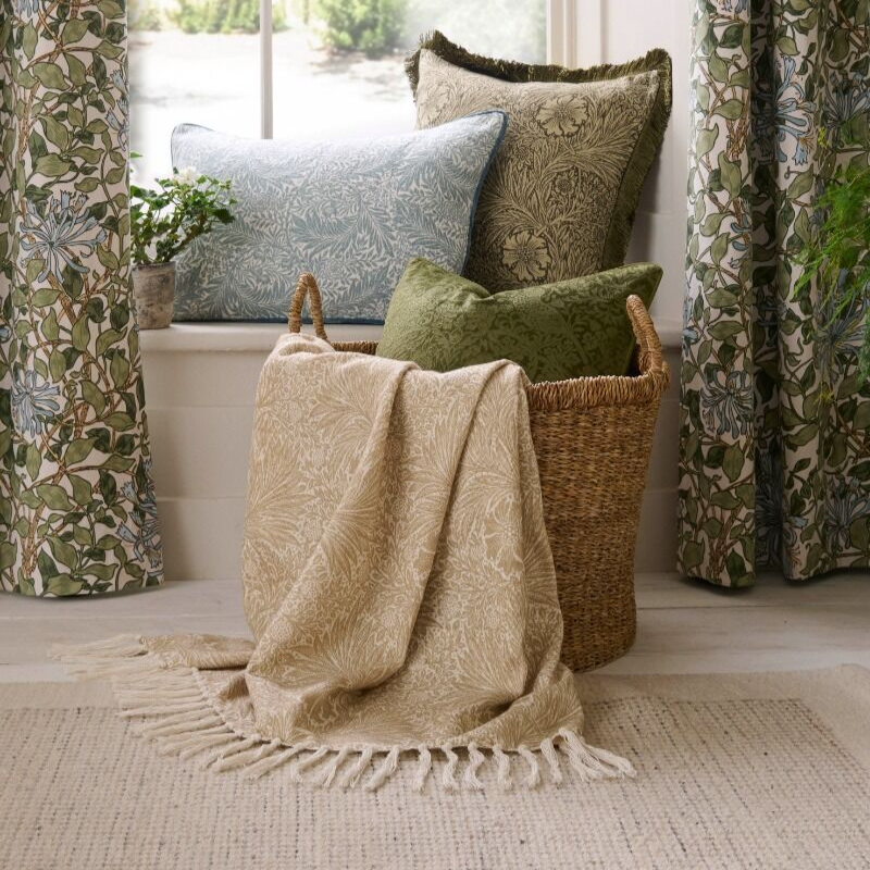 Decorative pillows and blanket on a windowsill with floral curtains