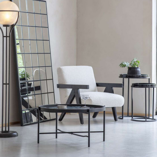 Modern interior with a white armchair, black floor lamp, and side table.