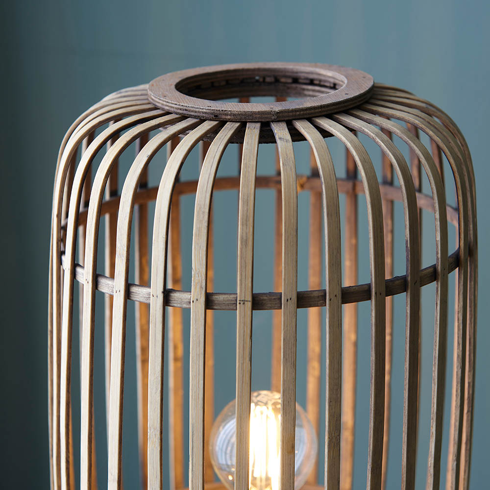 Wooden lamp with a visible light bulb against a blue background