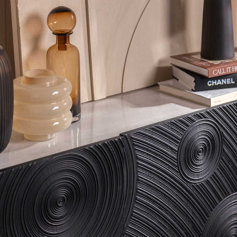 Decorative black textured console table with a white surface and decorative items.