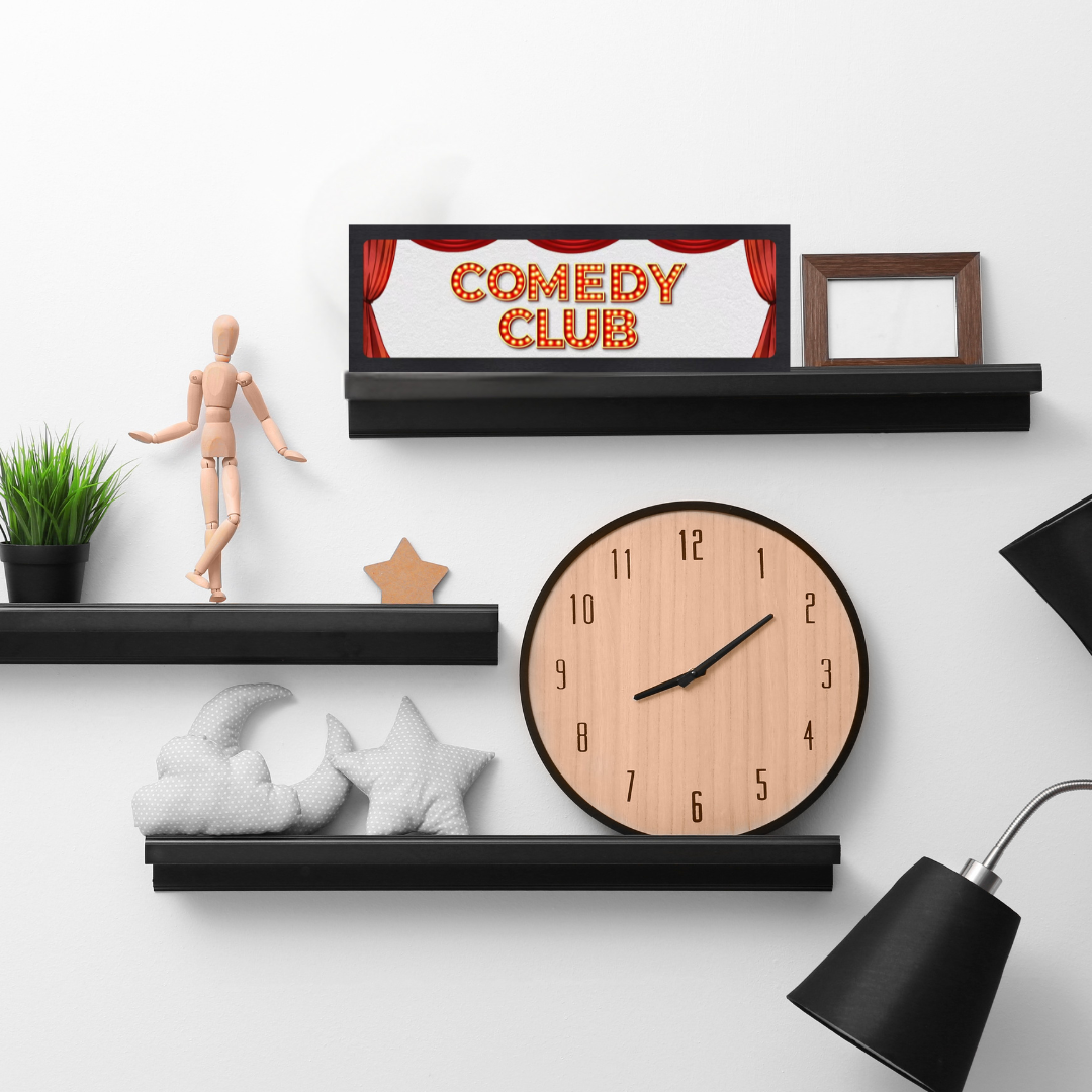 Wall shelf with decorative items including a clock, framed picture, and small statue on a white background.
