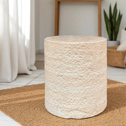 Textured cylindrical side table in a home setting with curtains and decor.