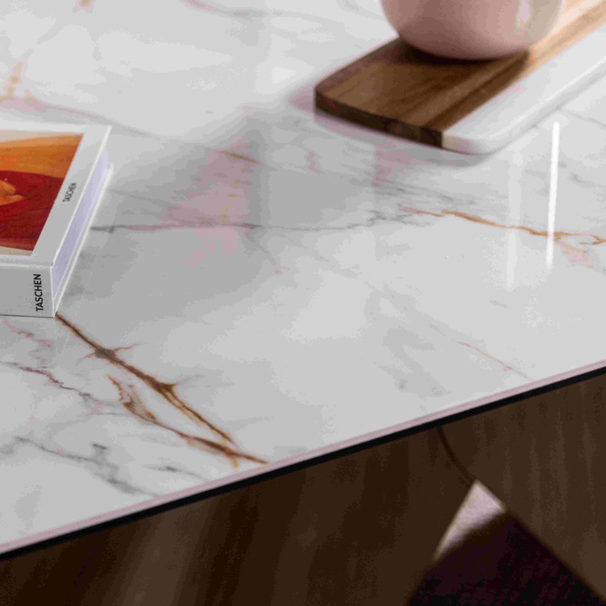 Marble-patterned table with a book, glass, and small decorative items.