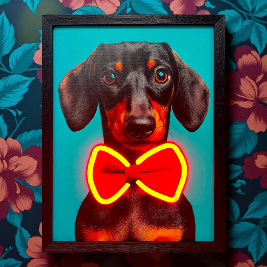 Framed artwork of a dog with a red bow tie against a floral background