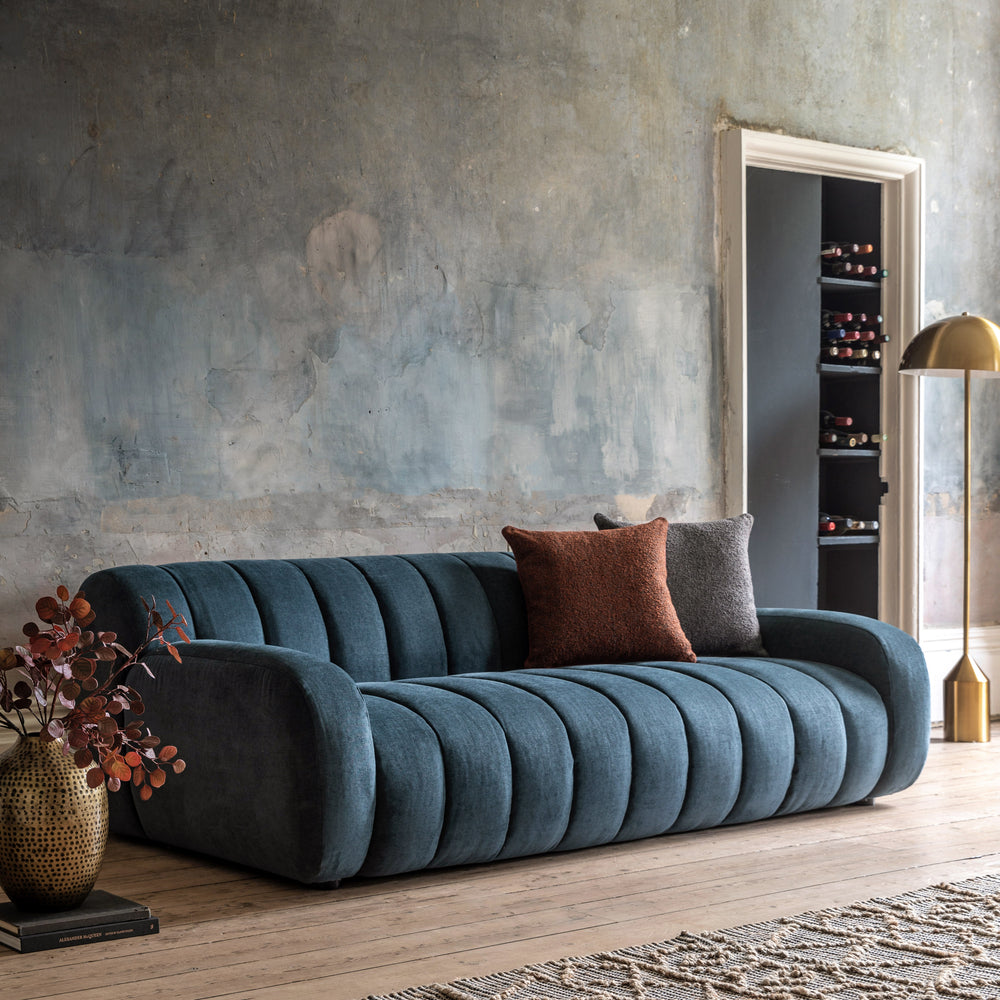 Blue sofa with decorative pillows in a modern living room setting.