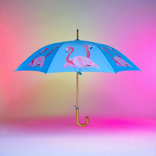 Blue umbrella with pink flamingo design on a gradient background