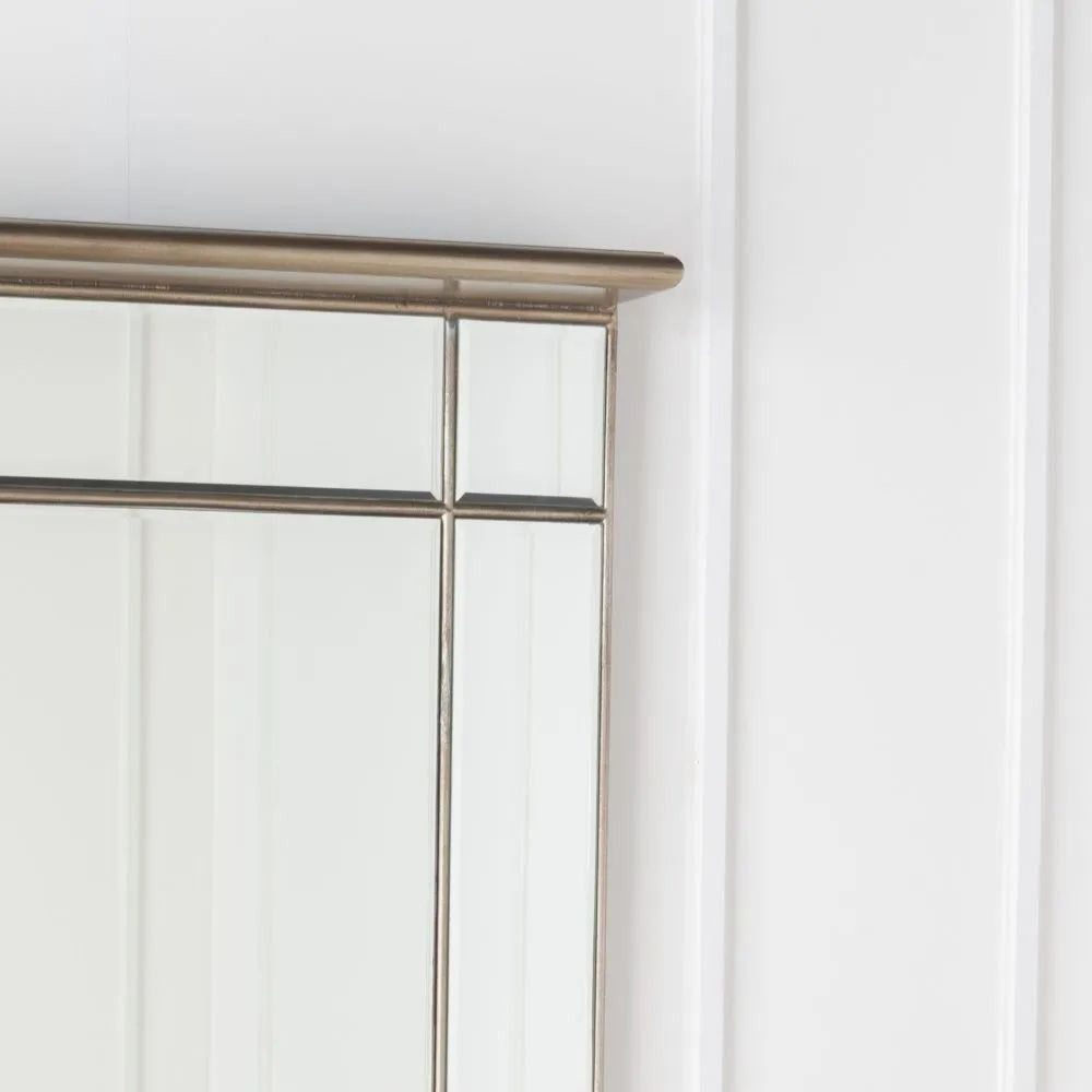 Metallic-framed mirror on a white wall