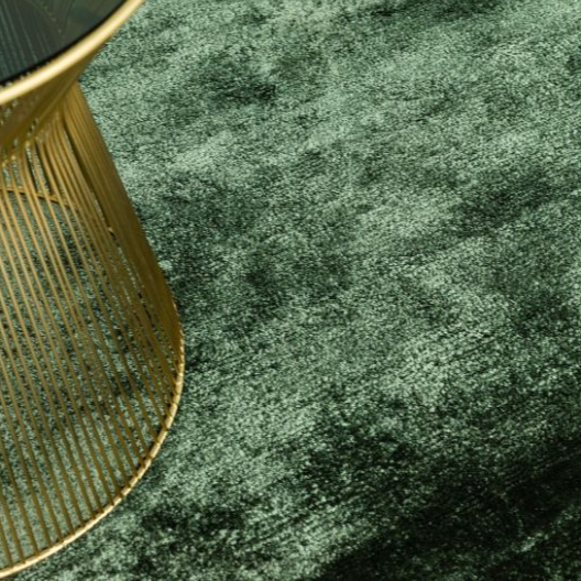 Green textured rug with a gold side table and smartphone on a white background