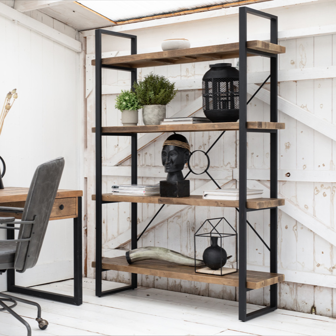 Home office with wooden desk, chair, and bookshelf against a white wall.