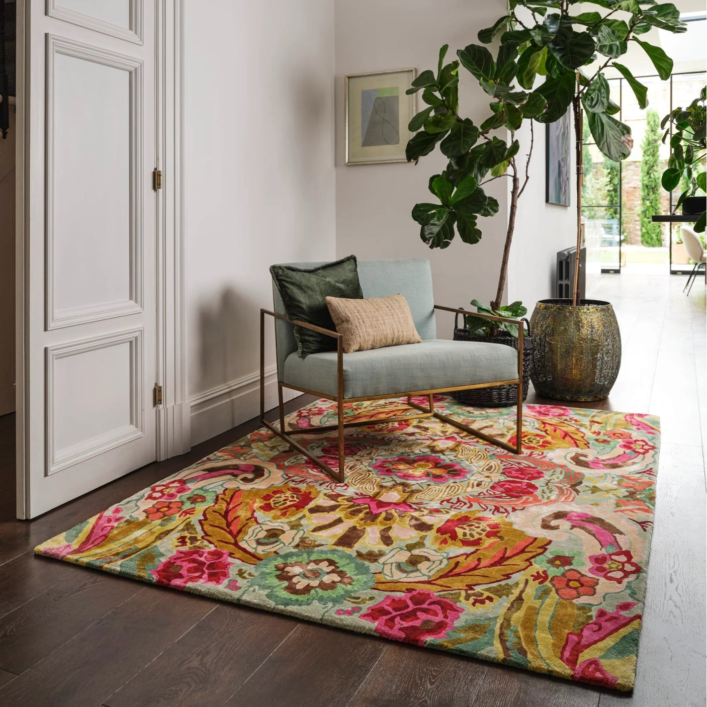 Colorful floral rug on a wooden floor with a chair and decorative elements.