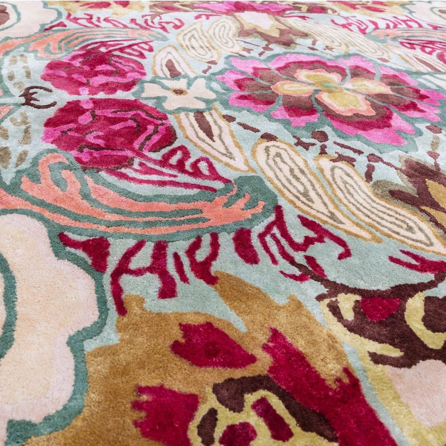Close-up of a colorful floral patterned rug with vibrant pink, red, and gold colors.