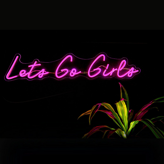 Neon sign with 'Let's Go Girls' text on a dark background