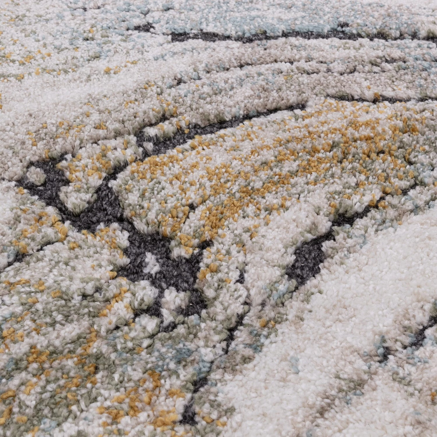 Close-up of a textured rug with white, gray, and gold colors