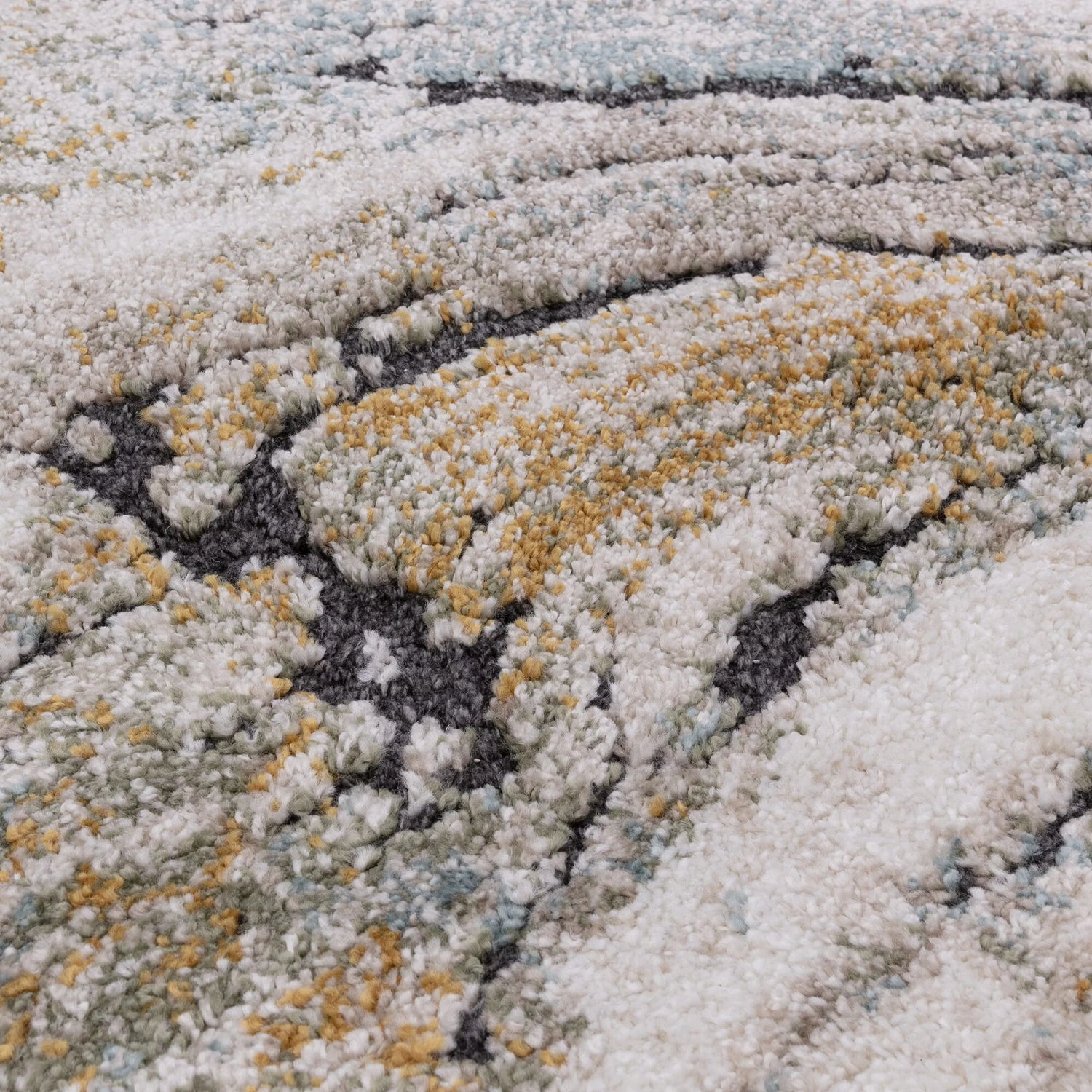 Close-up of a textured rug with white, gray, and gold colors