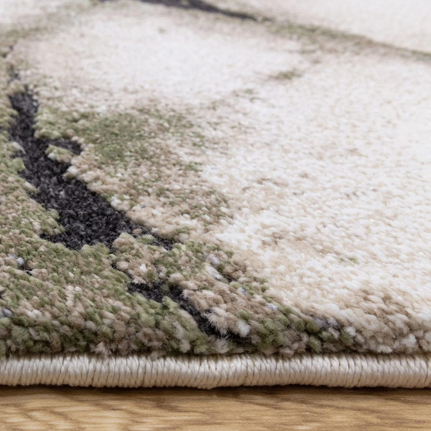 Close-up of a textured rug with a camouflage pattern on a wooden floor.
