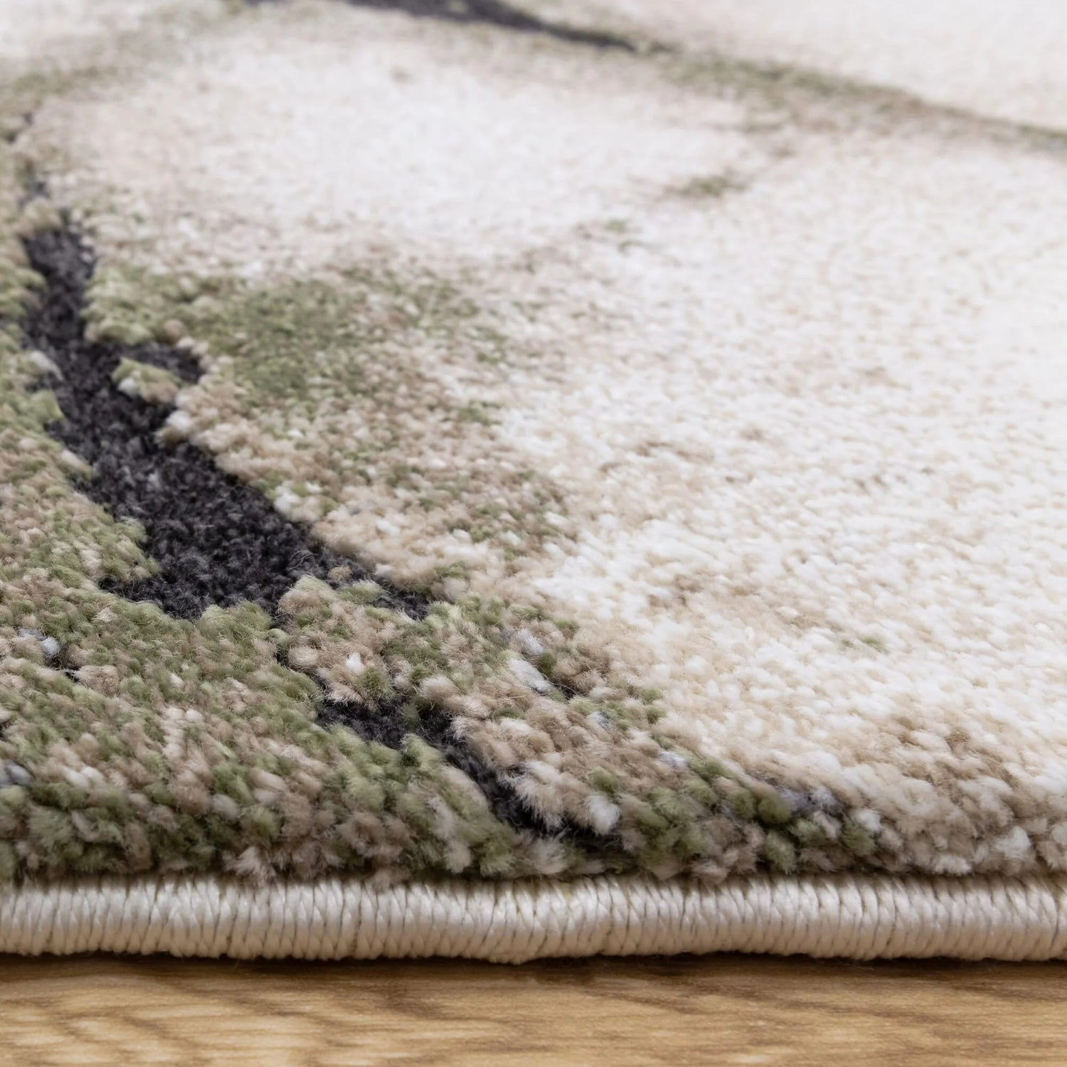 Close-up of a textured rug with a camouflage pattern on a wooden floor.
