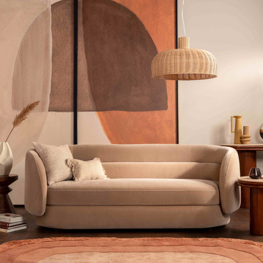 Beige sofa in a living room with abstract art and wooden furniture.