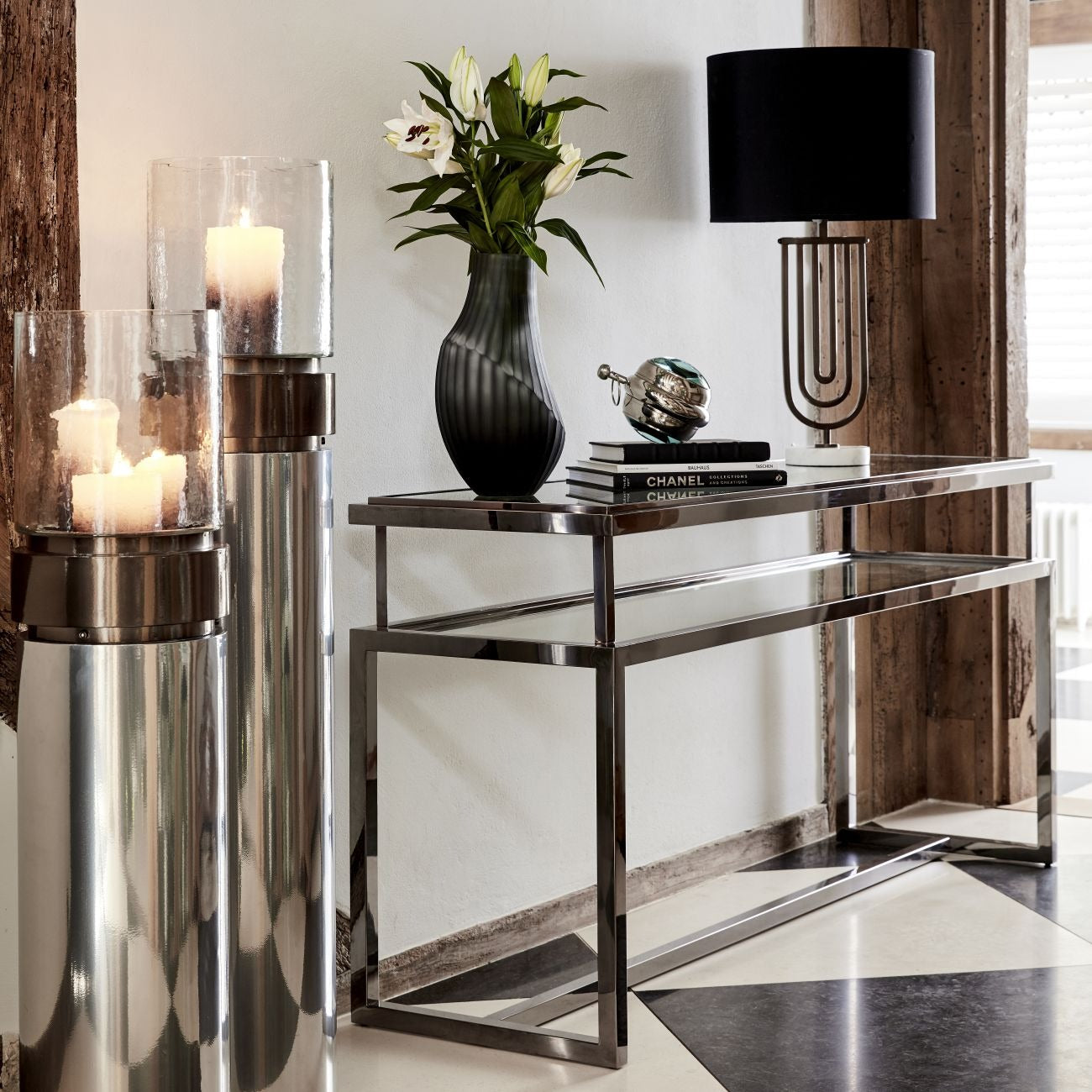 Modern console table with decorative items including a vase, books, and a lamp.