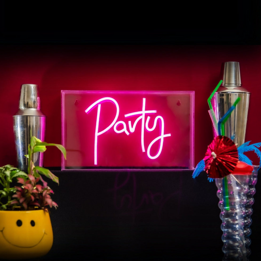 Neon sign that says 'Party' with cocktail shakers and a plant on a dark background