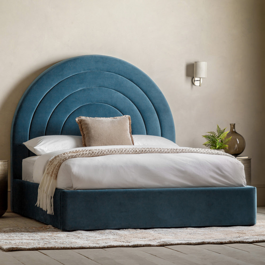 Blue upholstered bed with circular headboard in a bedroom setting
