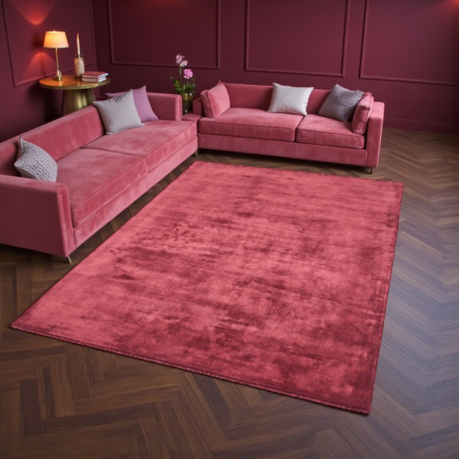 Pink sectional sofa with matching rug in a room with purple walls.