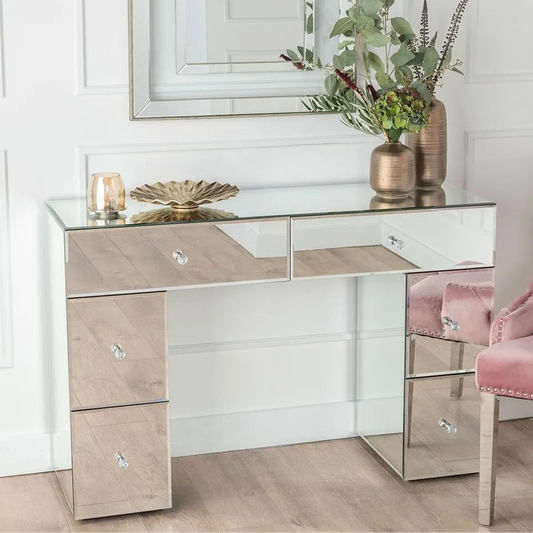 Modern mirrored desk with decorative items in a stylish room.