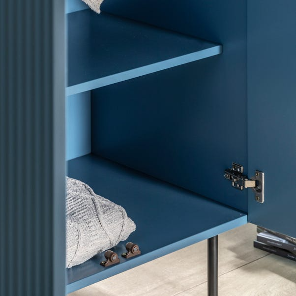 Blue wardrobe with open door revealing a shelf and folded fabric.