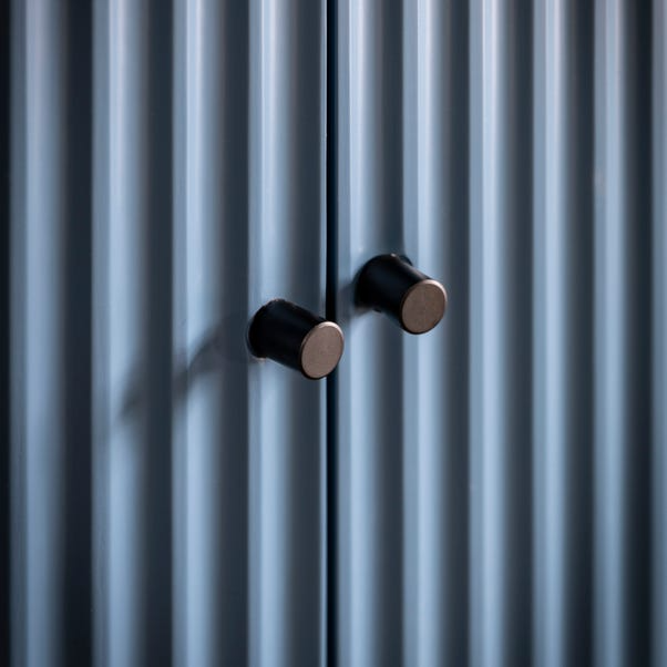 Two black cabinet knobs on a blue surface