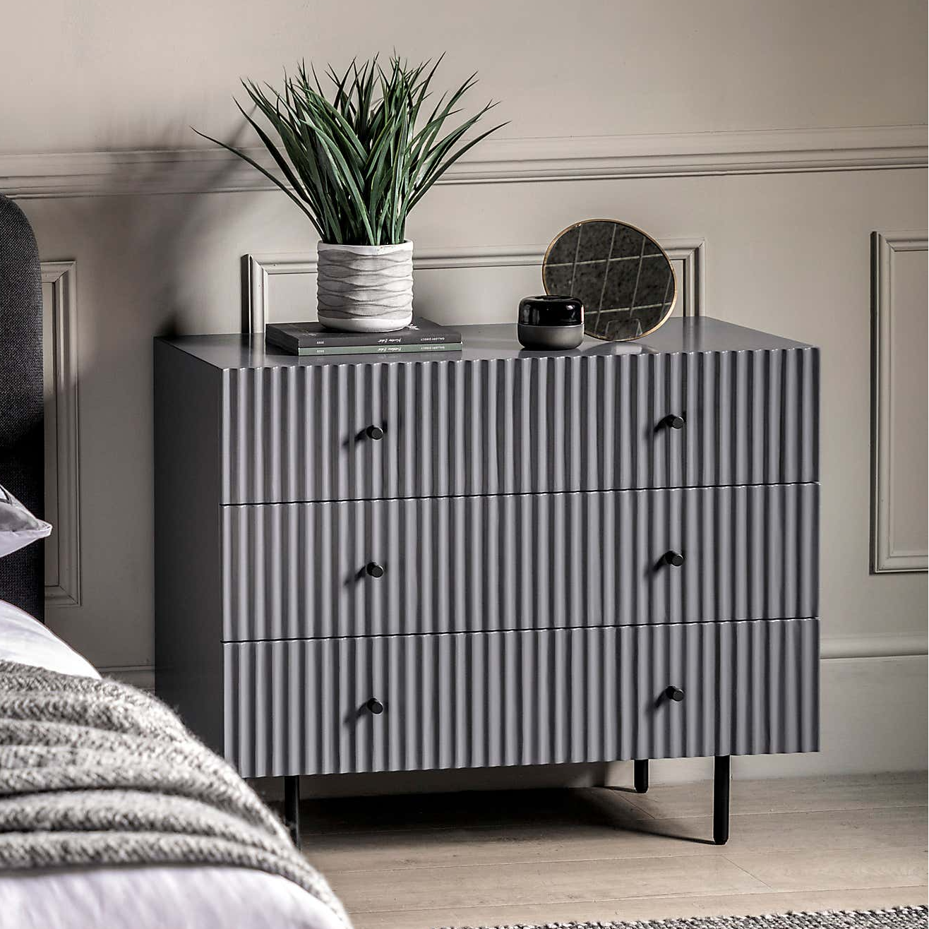 Gray dresser with decorative items in a bedroom setting